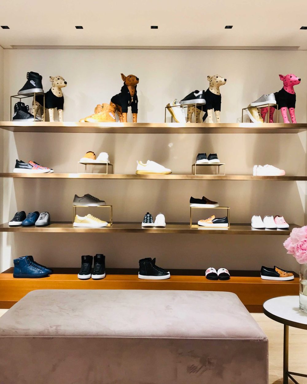A sneaker display wall topped with a row of the brand's dressed canine figures.