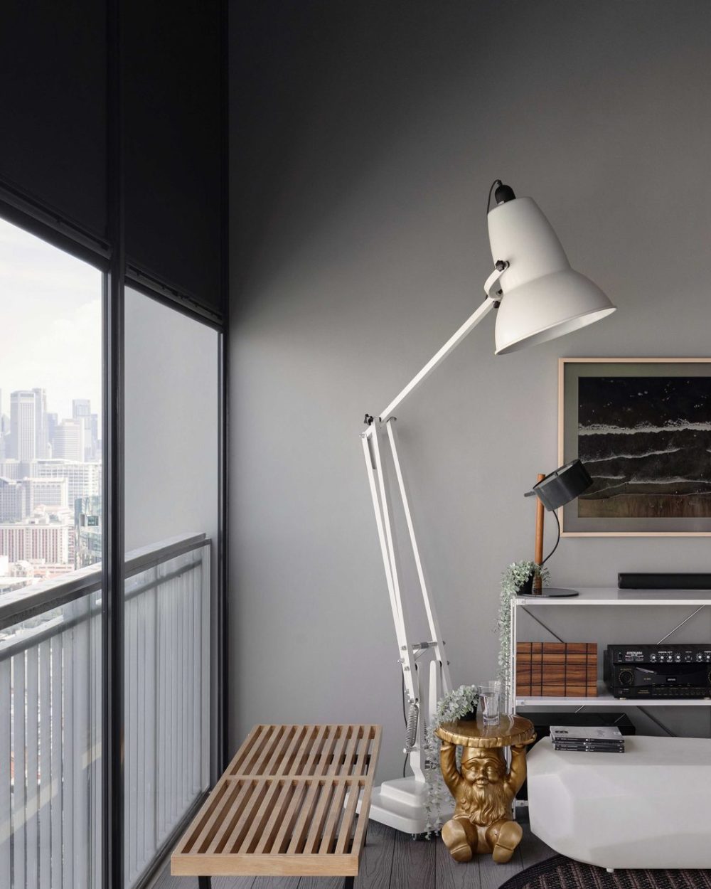 Open shelving stocked with board games and a plush white bench turn the balcony into a relaxed hangout spot, with sweeping skyline views beyond.