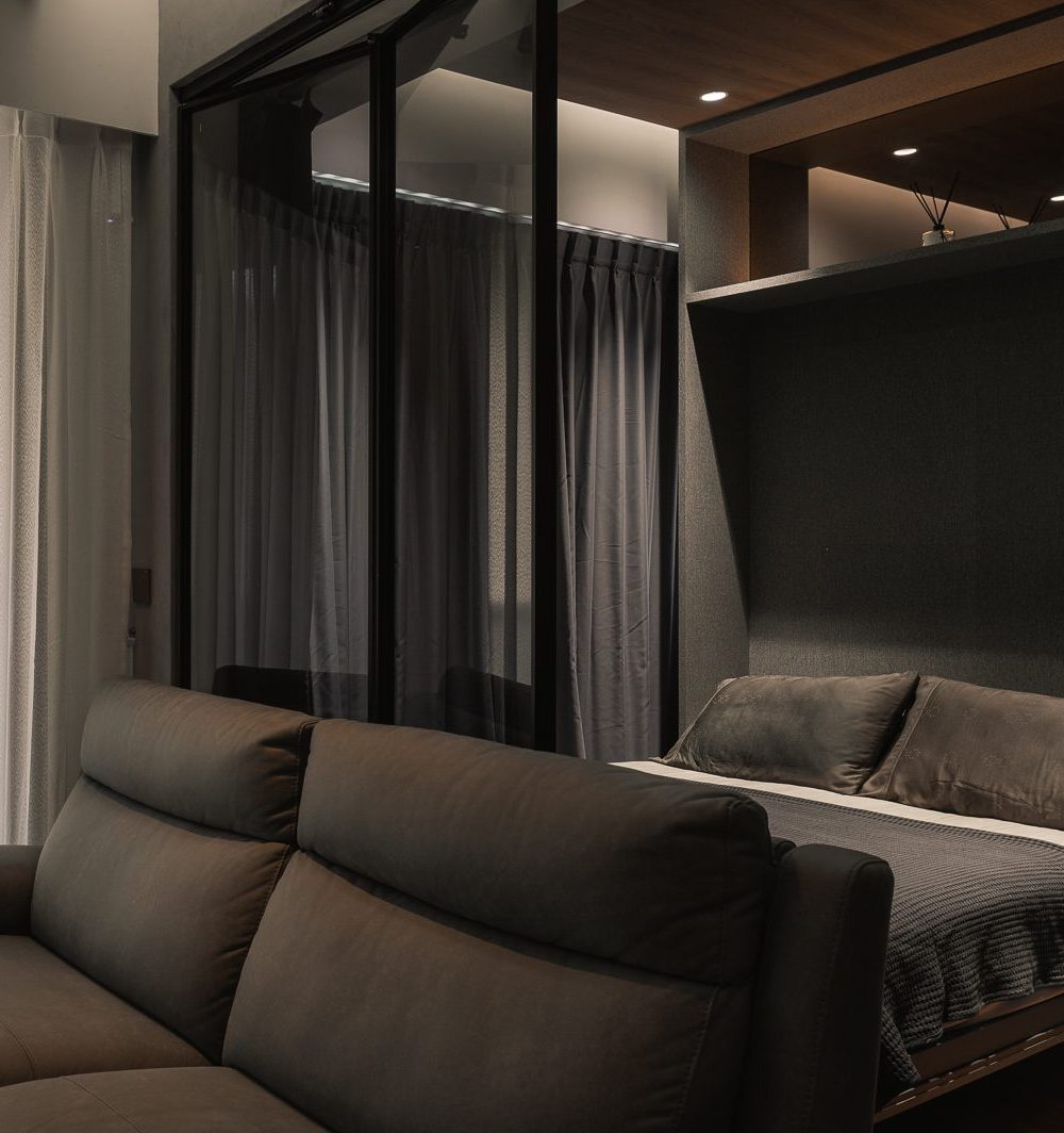 A stone-topped bar counter with a suspended glass wine rack doubles as a small entertaining nook beside the fold-down bed.