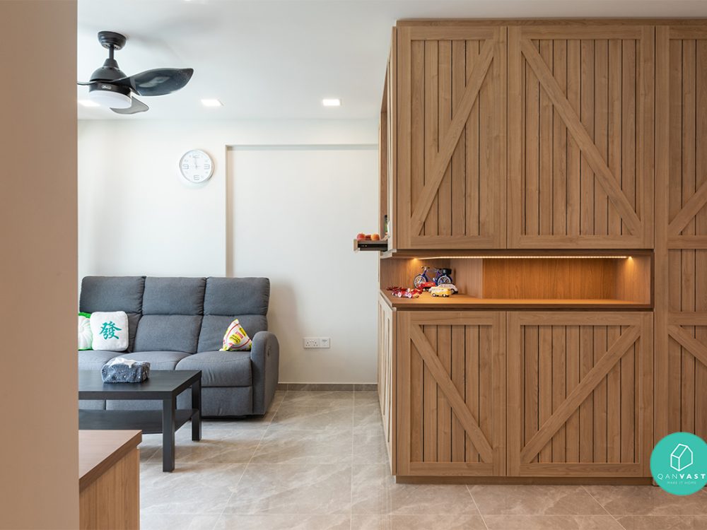 Full-height timber cabinetry with diagonal cross-bracing brings a rustic barn-door character to the living area, complete with a backlit open display