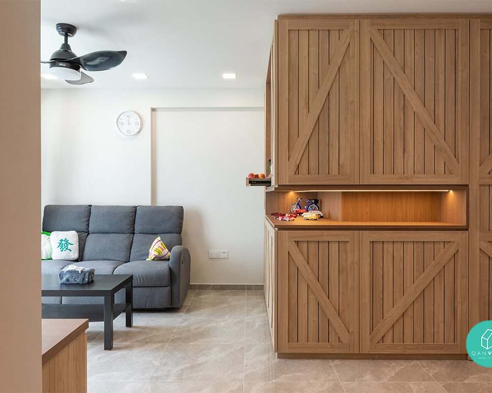 Full-height timber cabinetry with diagonal cross-bracing brings a rustic barn-door character to the living area, complete with a backlit open display