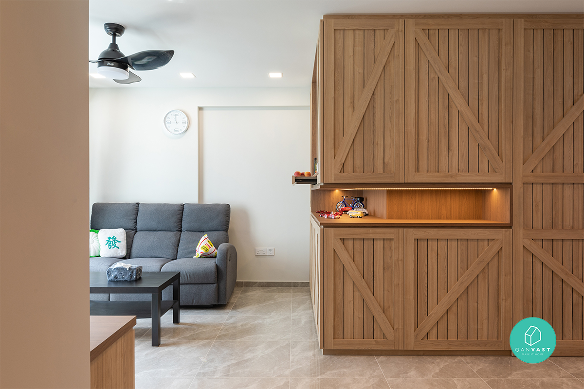Full-height timber cabinetry with diagonal cross-bracing brings a rustic barn-door character to the living area, complete with a backlit open display
