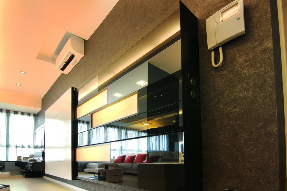 Backlit amber-glass panels and a glossy black finish define a feature partition near the living area, which also discreetly houses the home's intercom