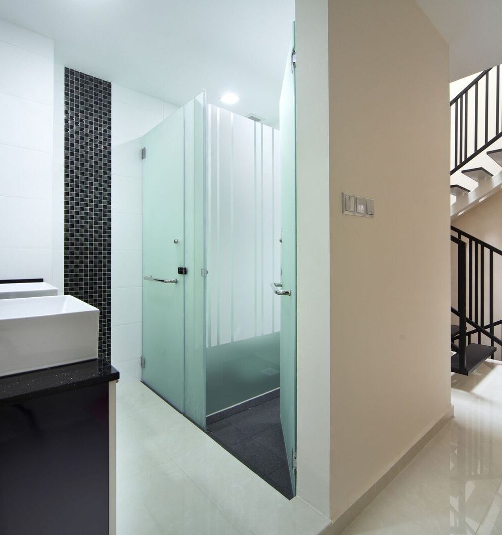 A black mosaic feature wall and frosted glass shower door define this ensuite bathroom, just steps from the staircase landing.