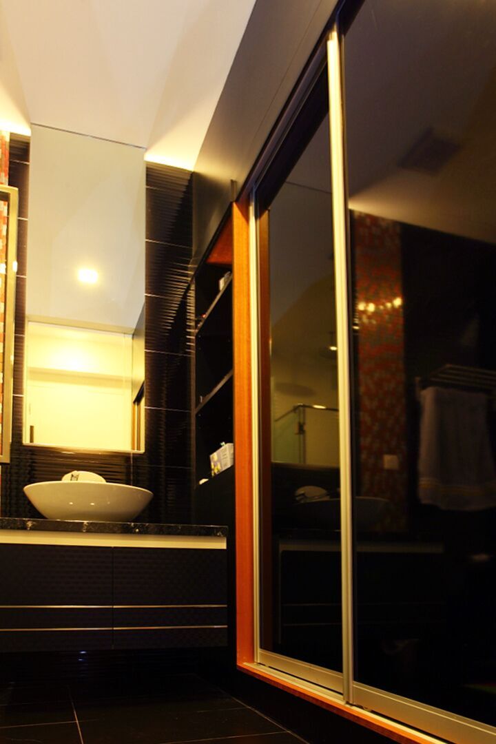 A black stone counter and vessel sink pair with a richly patterned feature wall in the ensuite bathroom.