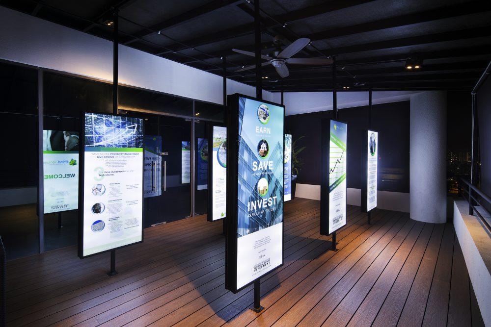 A row of illuminated signage panels spells out the company's core messages, doubling as a design feature along the terrace walkway.