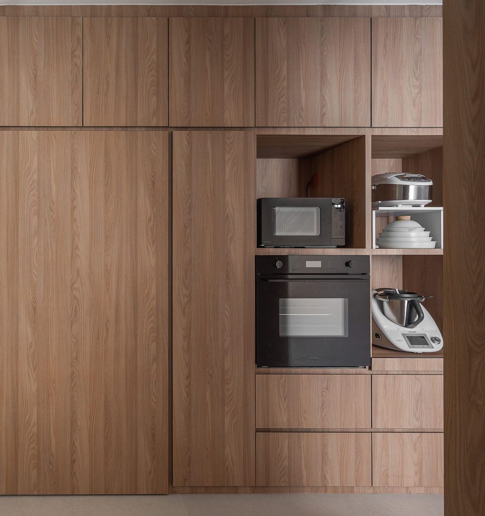 A microwave, oven and premium kitchen appliances are neatly built into timber joinery, keeping the counters clear.