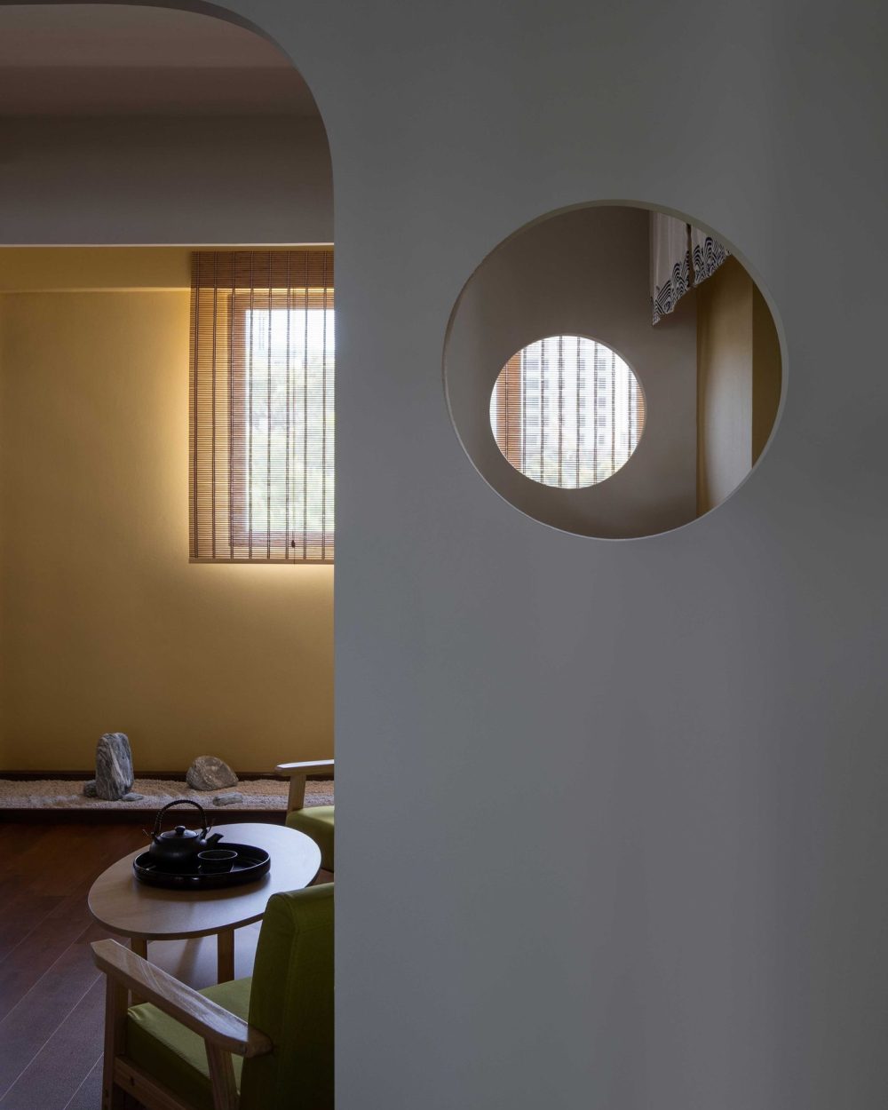 A smaller round opening nested within a larger one plays with light and framed views between rooms.
