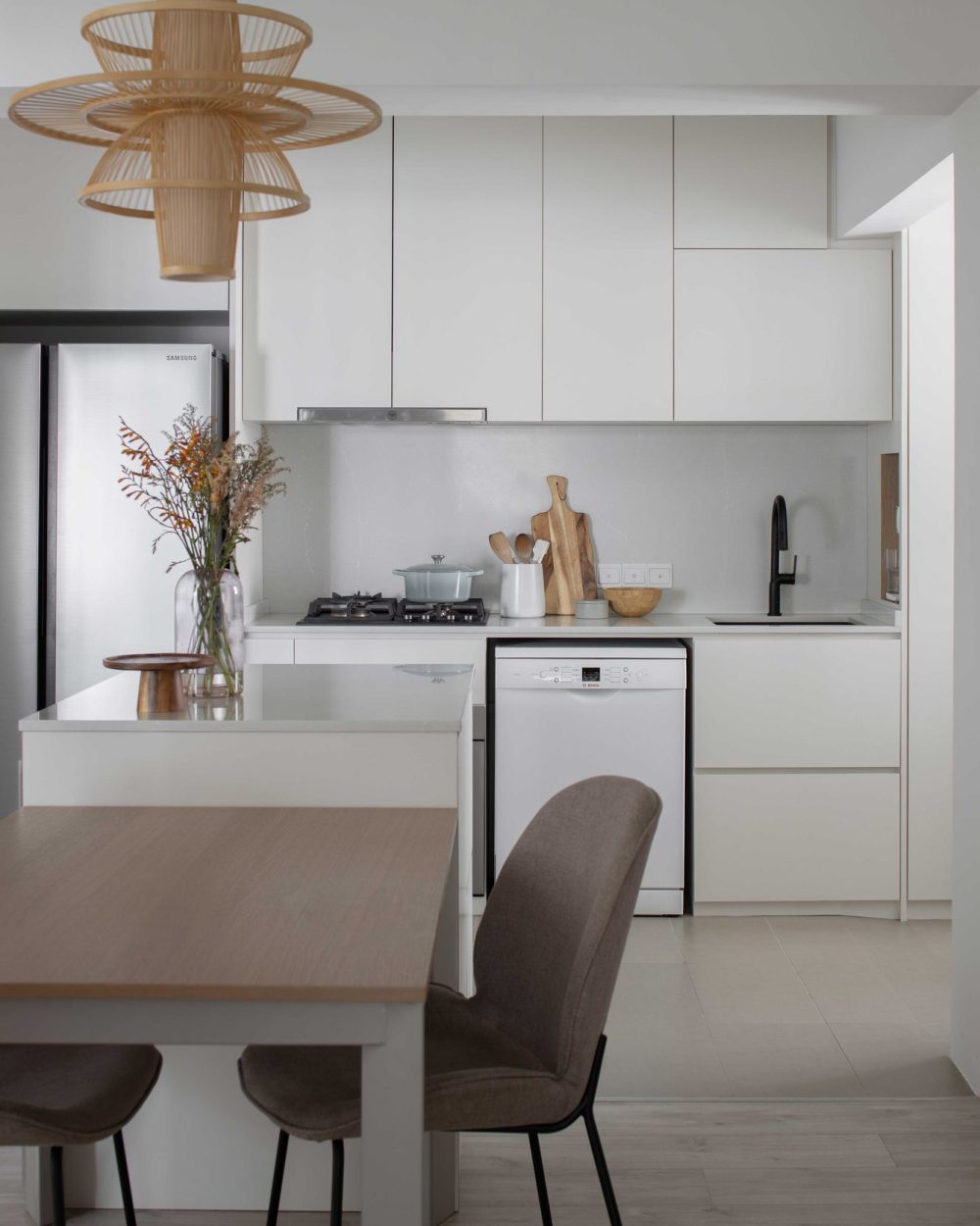 White cabinetry and a stainless steel hood keep the kitchen bright, with dried florals adding a warm, natural touch.
