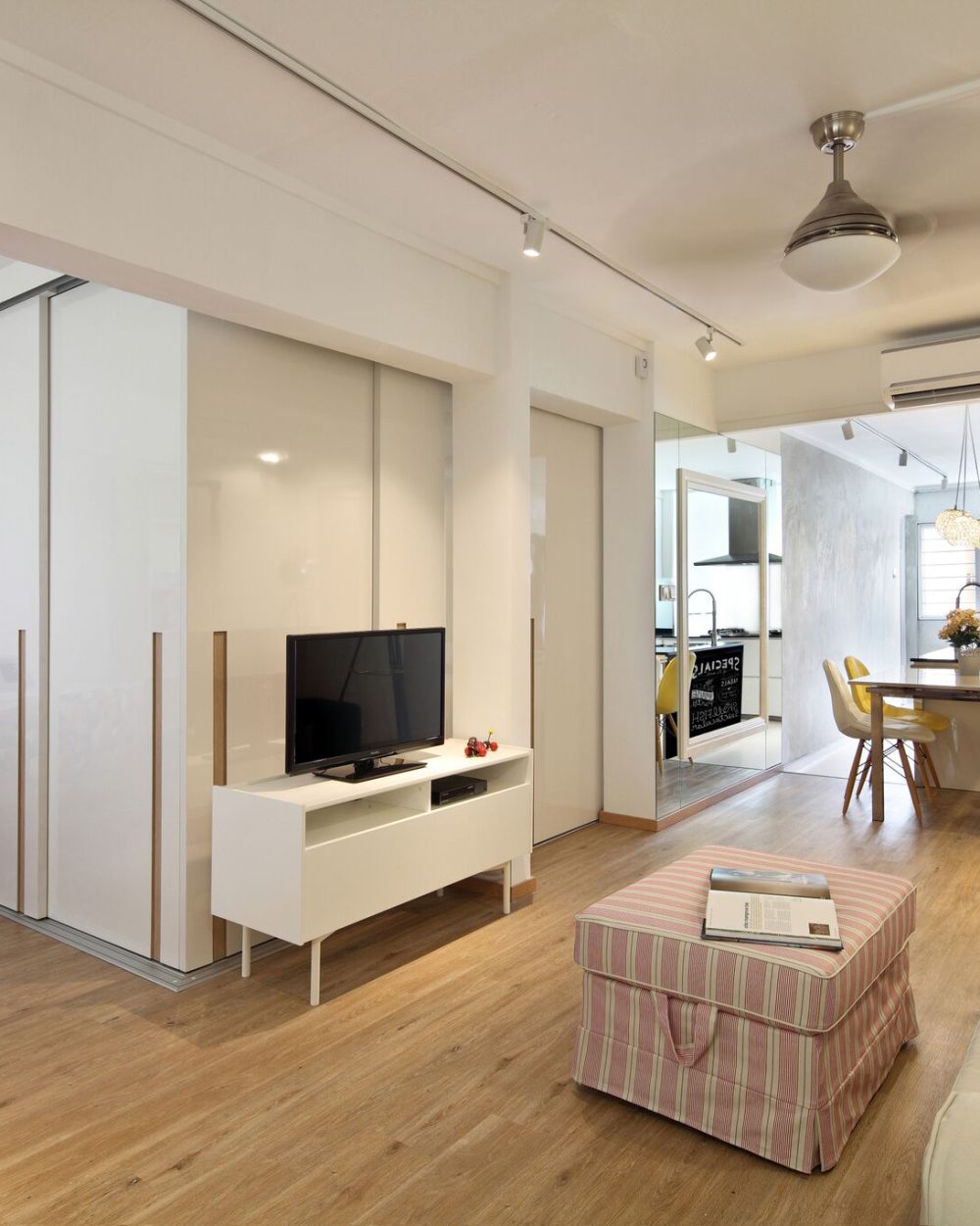 The same sliding doors close off a media nook with a wall-mounted TV, giving the household a quiet, separate space when needed.
