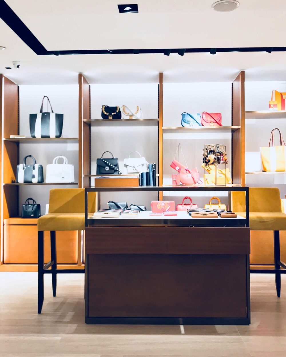 Tote bags and crossbody bags on display beside a mannequin in the season's ready-to-wear.