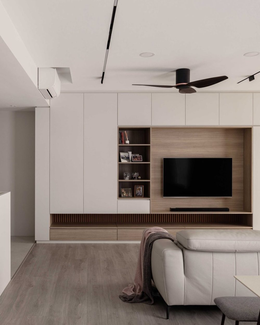 Open timber shelving breaks up the white cabinetry, styled simply with books and family photographs.