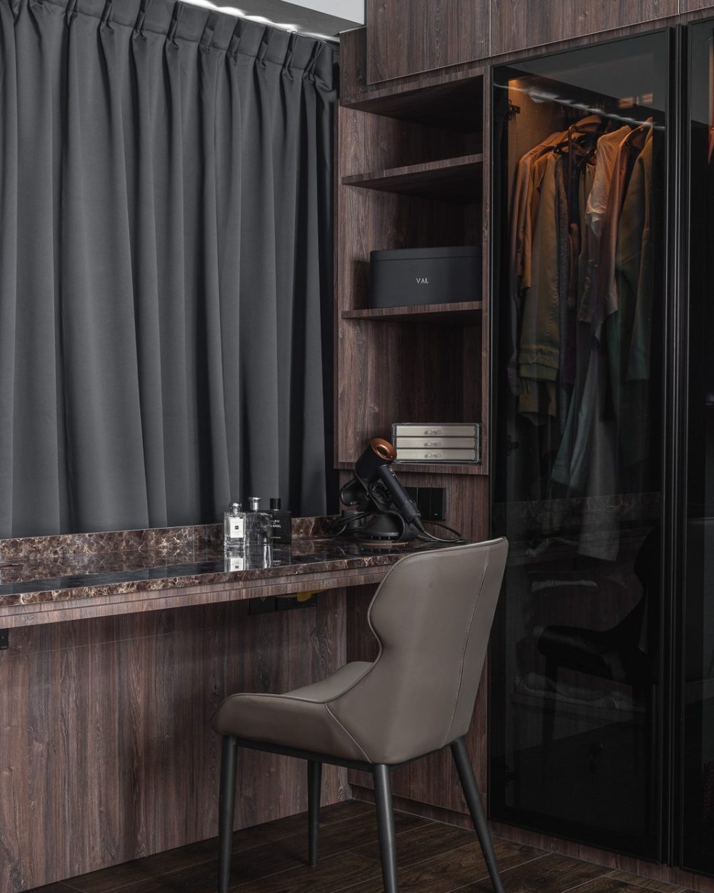 A hairdryer, colognes and grooming tools sit ready on the marble dressing counter, framed by open display shelving.