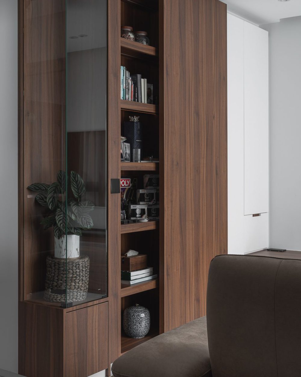 Glass jars, coffee-table books and ceramic vases are arranged on the display cabinet's shelves, each lit individually.