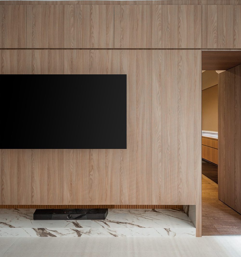 The same panelled wall continues around the room, its hidden door leading to a warmly lit hallway.