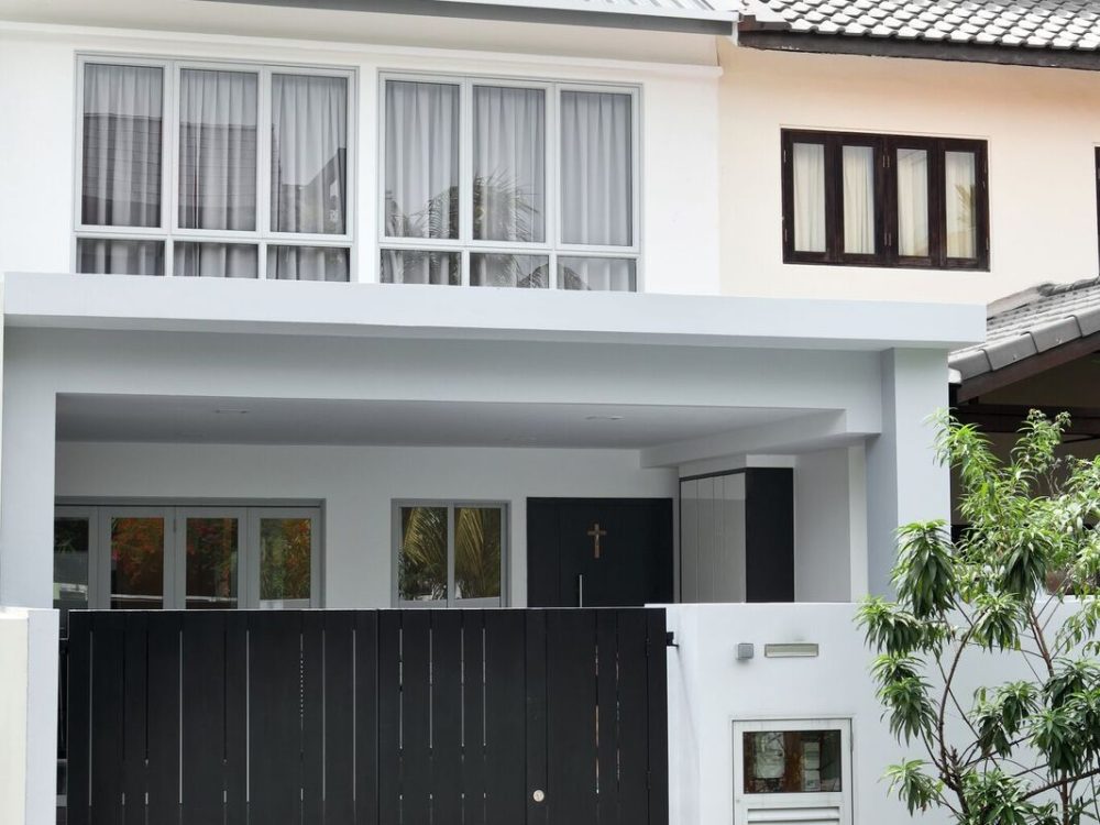A two-storey white and grey facade with a slatted black gate gives this landed home a clean, contemporary street presence.