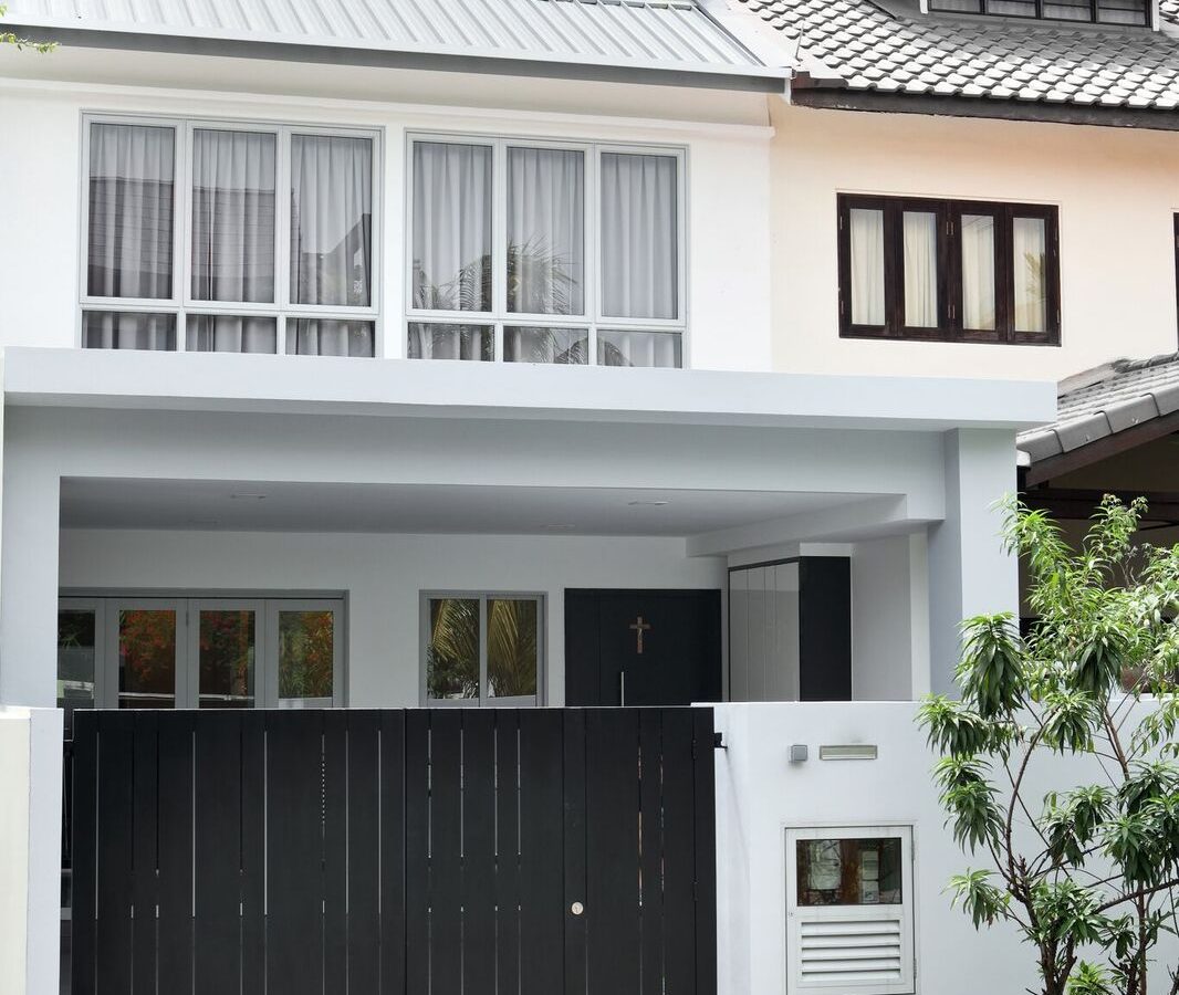 A two-storey white and grey facade with a slatted black gate gives this landed home a clean, contemporary street presence.