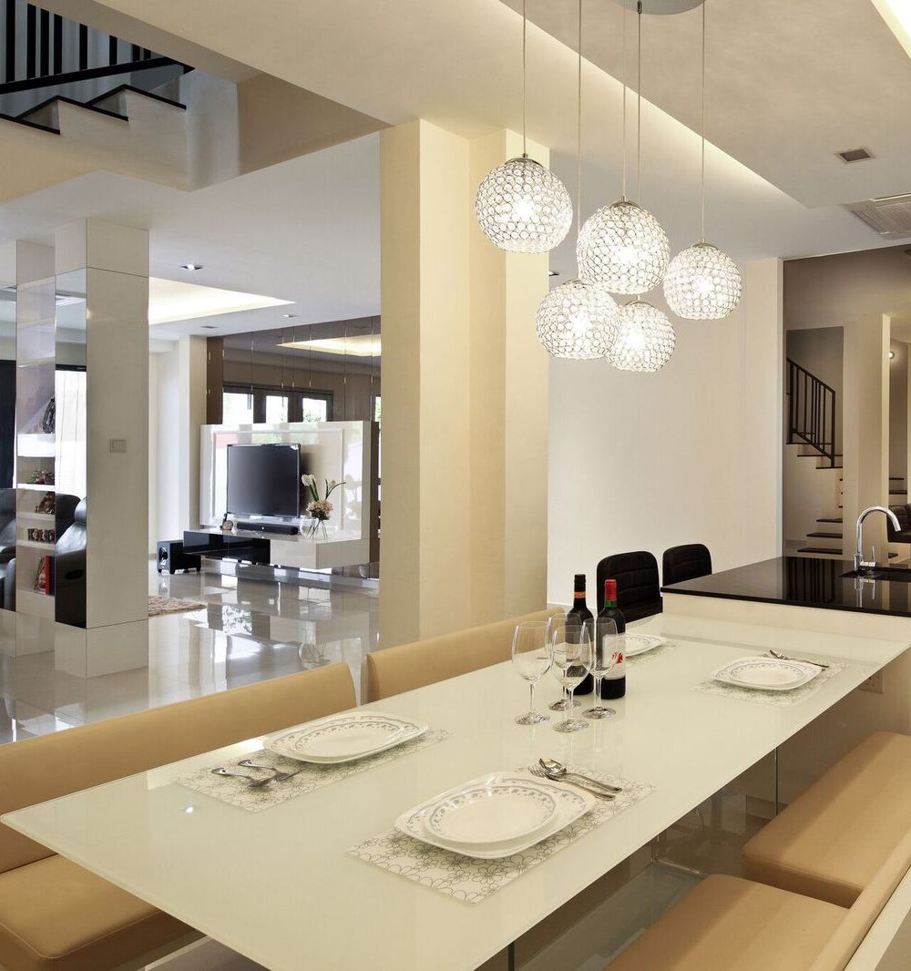 A cluster of crystal ball pendants lights the dining area beside an open staircase, with the kitchen visible through a mirrored partition.
