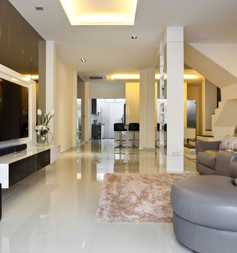 A dark mirrored panel wraps the TV wall, paired with a brown leather sofa and a plush shag rug in the open-plan living area.
