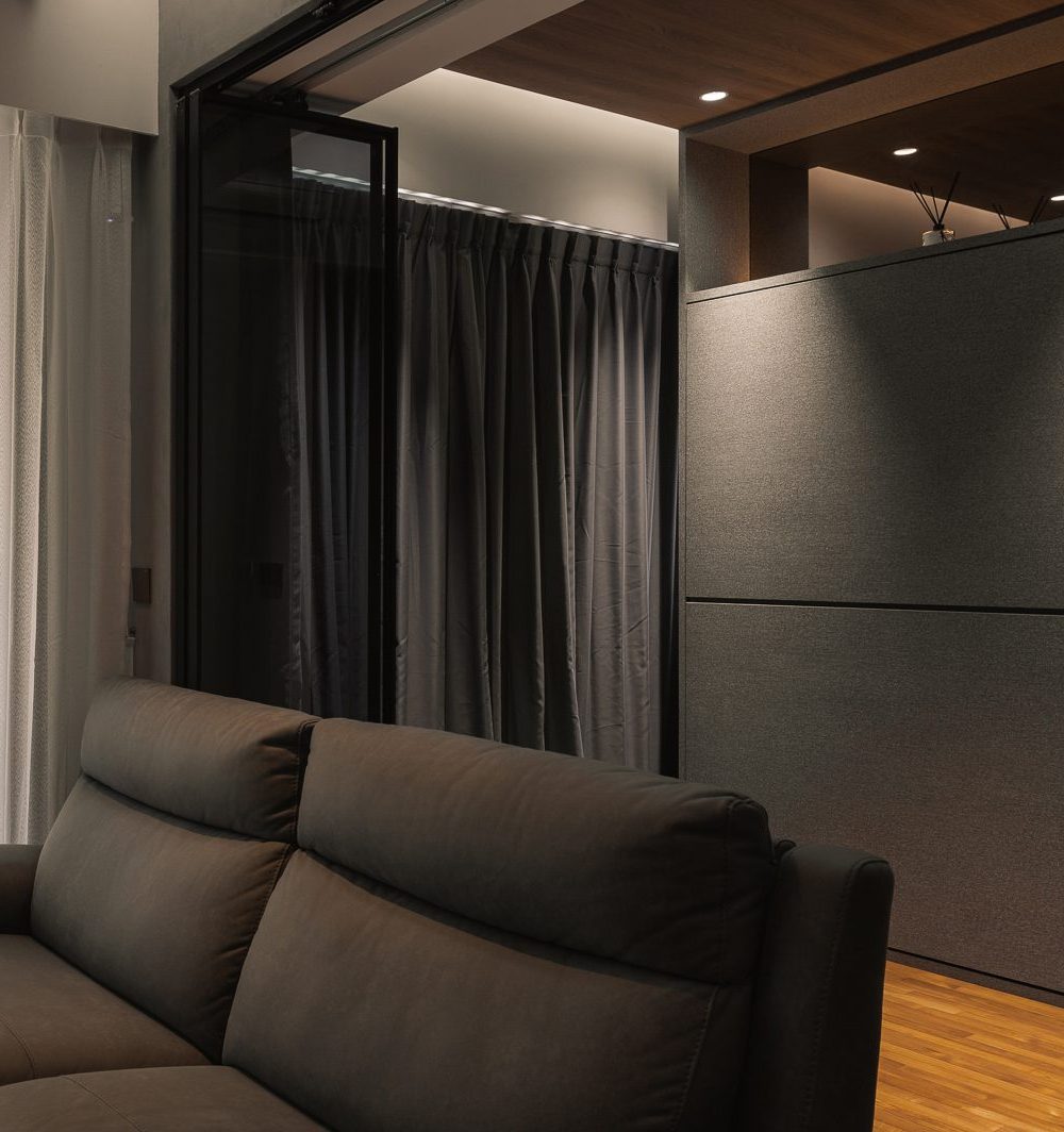 A fold-down bed built into dark upholstered cabinetry gives the living area flexible guest accommodation without a dedicated room.