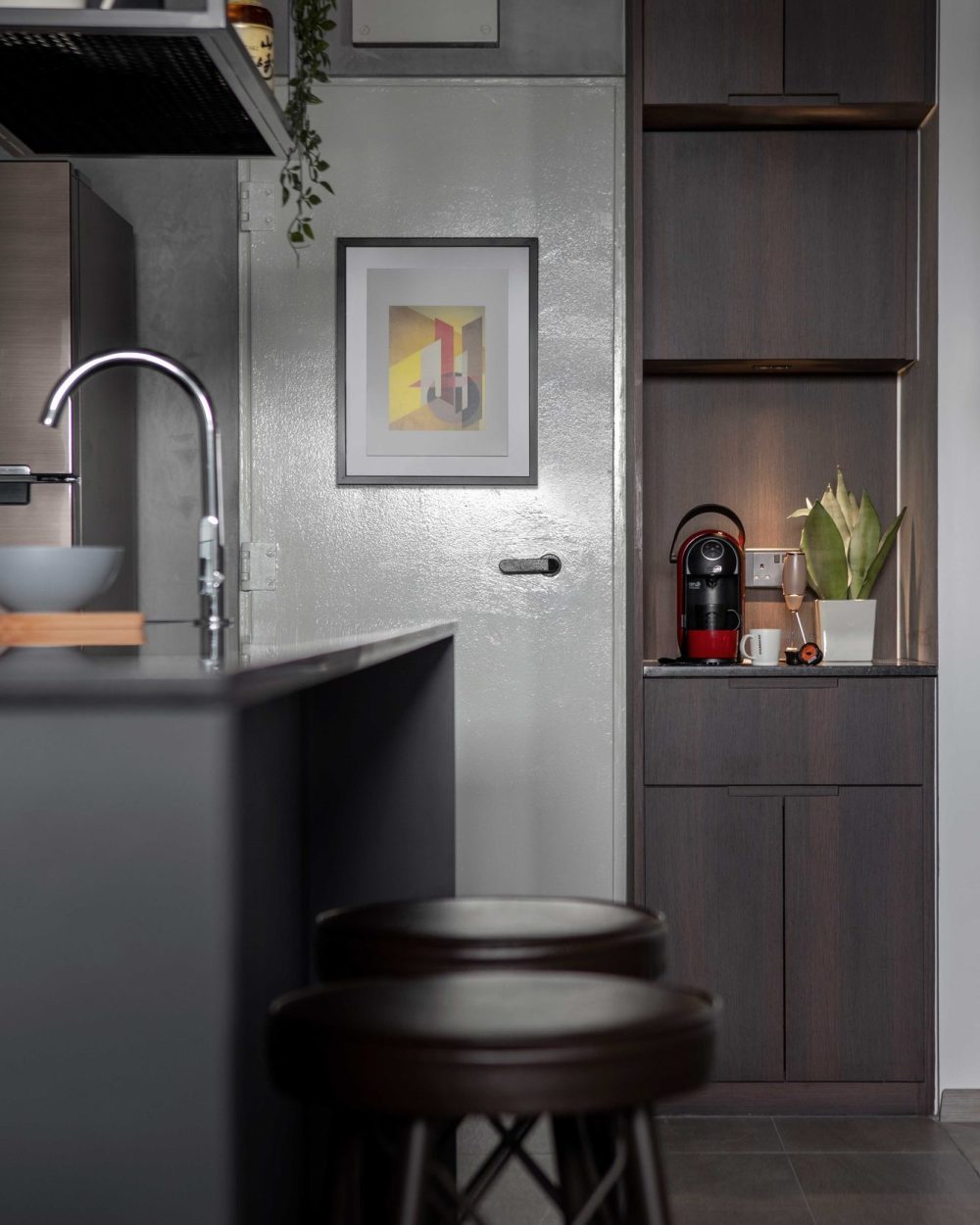 A geometric print and a red espresso machine bring colour to this corner of the kitchen, styled with trailing plants.
