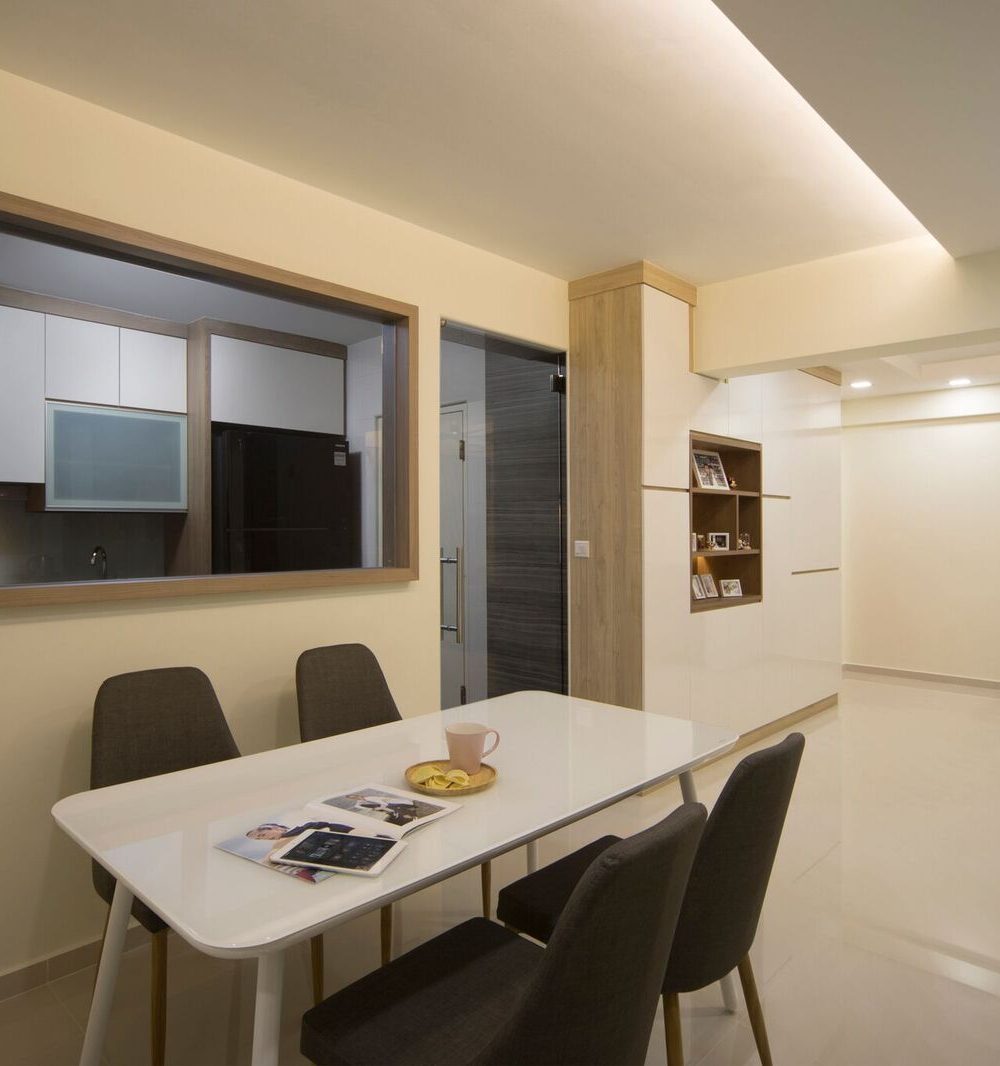 A timber-framed window connects the kitchen to the dining area, paired with a slim wood-and-white display shelf and a four-seat dining table.