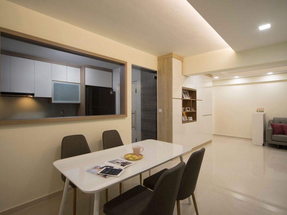 A timber-framed window connects the kitchen to the dining area, paired with a slim wood-and-white display shelf and a four-seat dining table.