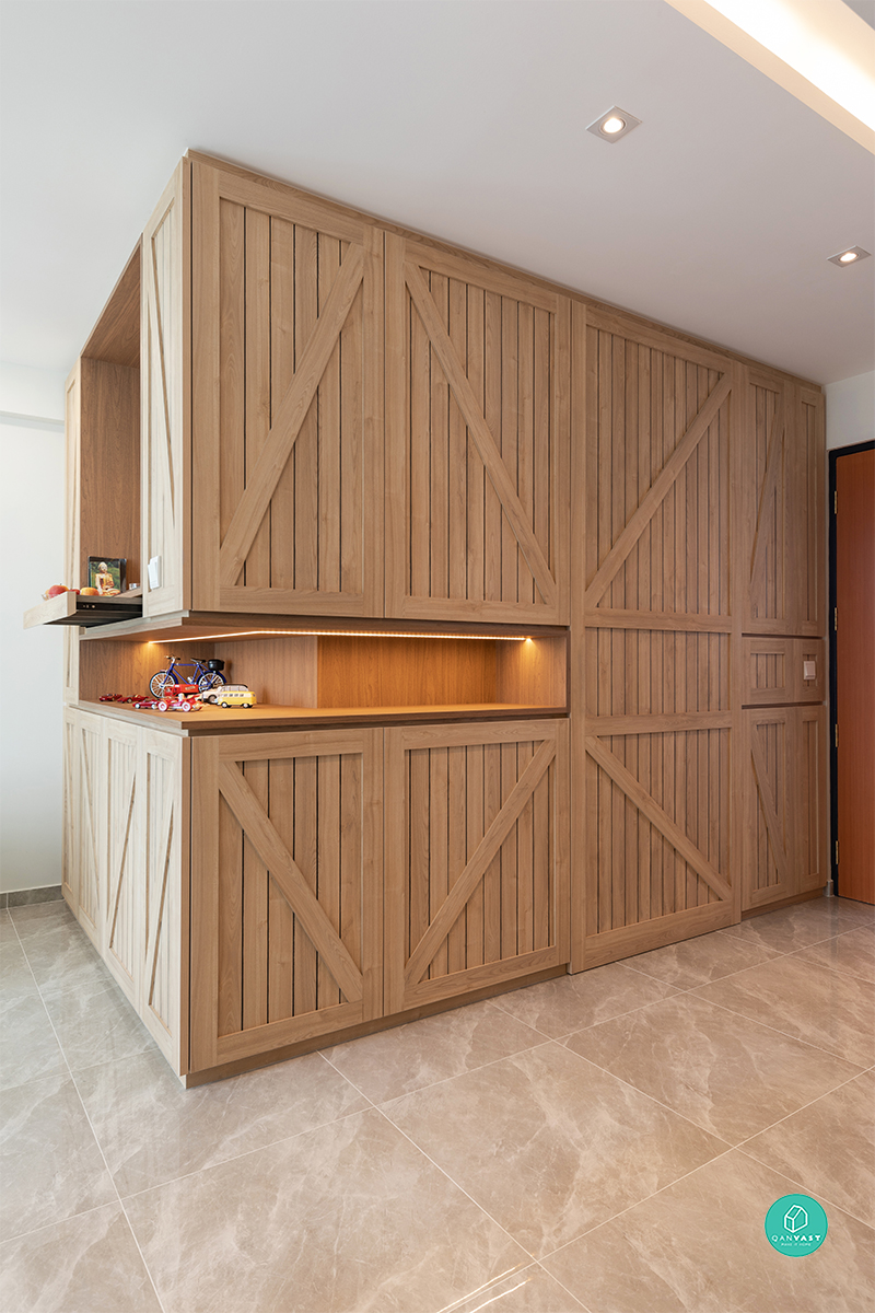 A closer view of the barn-door inspired carpentry, its vertical slats and diagonal braces adding texture across the full run of storage.