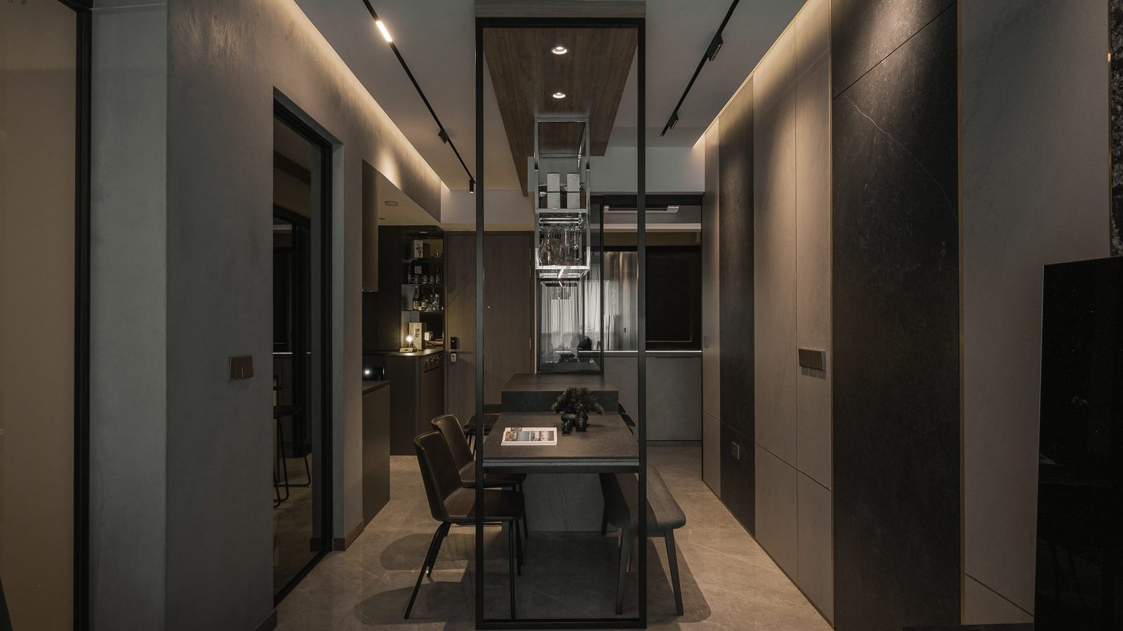 A suspended glass-and-steel wine rack anchors the dining area, framed by dark stone-clad walls and warm cove lighting.