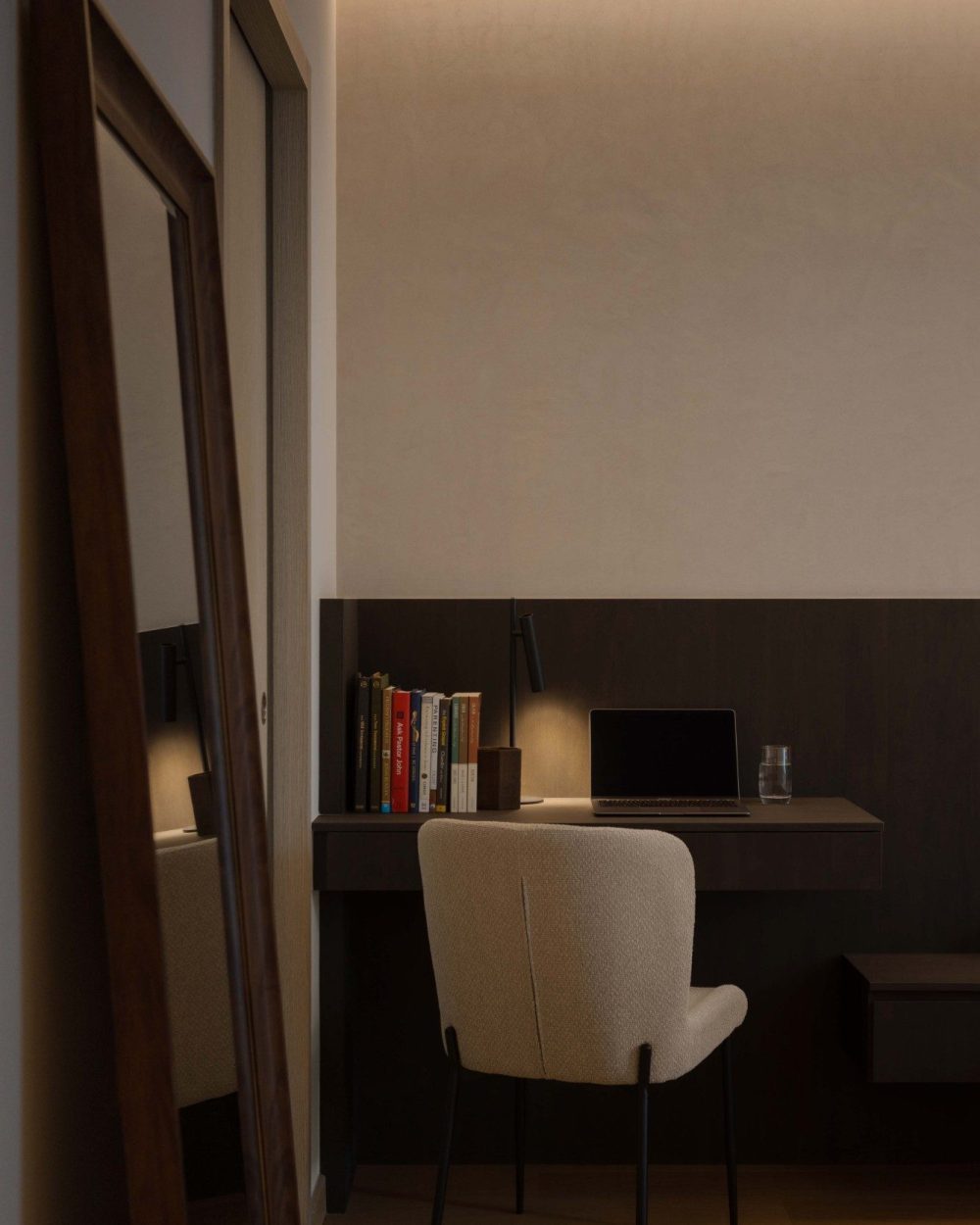 Seen through the bedroom doorway, the built-in desk and backlit shelving read as a continuous run of joinery, tying the sleeping and working zones tog