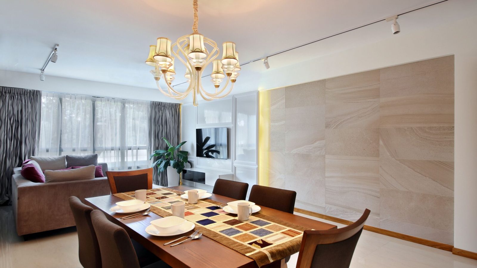 A crystal chandelier and stone-clad feature wall set a formal tone in the dining room, paired with a dark wood dining set for six.