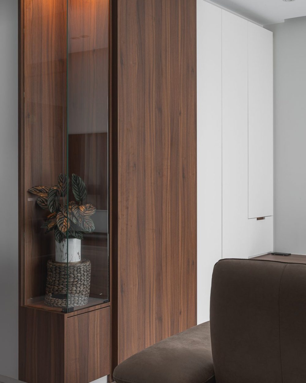 A full-height door blends into the walnut panelling, concealing generous shelving for games, books and display pieces.