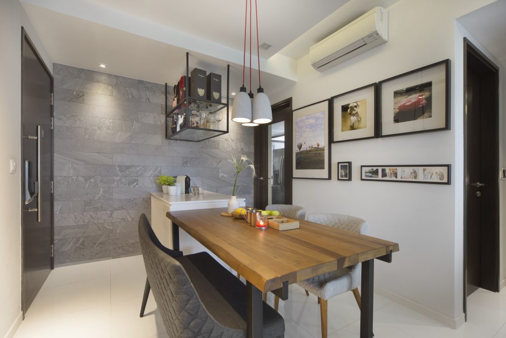 A grey marble-clad wall and a suspended glass bar shelf give the dining area a refined, tailored backdrop.