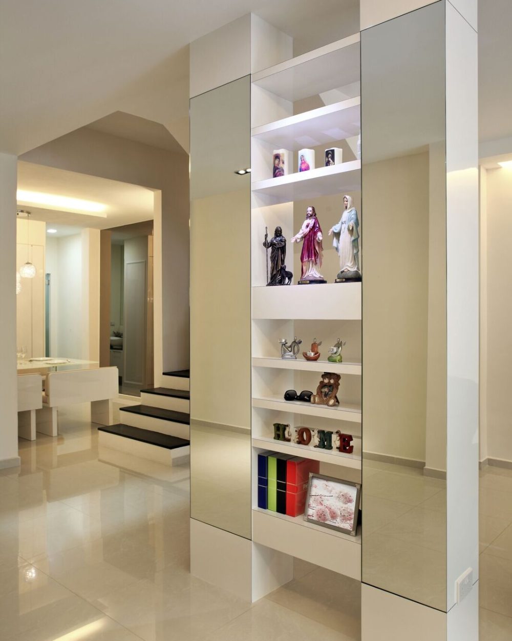 A slim mirrored column doubles as a display shelf for figurines and keepsakes, lit from within.