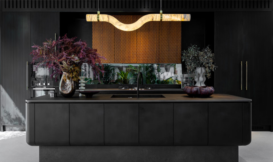 A sleek black modular kitchen island with a sculptural pendant light.