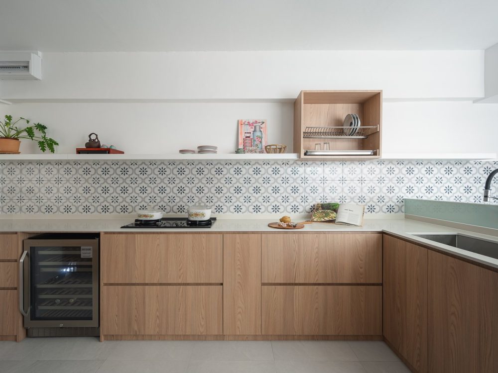 L-shaped kitchen with light oak cabinets, white quartz countertop, Peranakan tile backsplash, wine chiller and open floating shelf