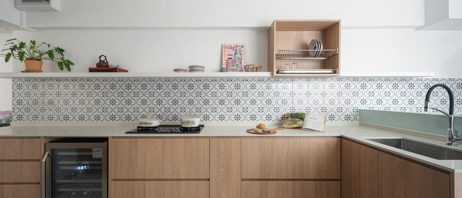 L-shaped kitchen with light oak cabinets, white quartz countertop, Peranakan tile backsplash, wine chiller and open floating shelf