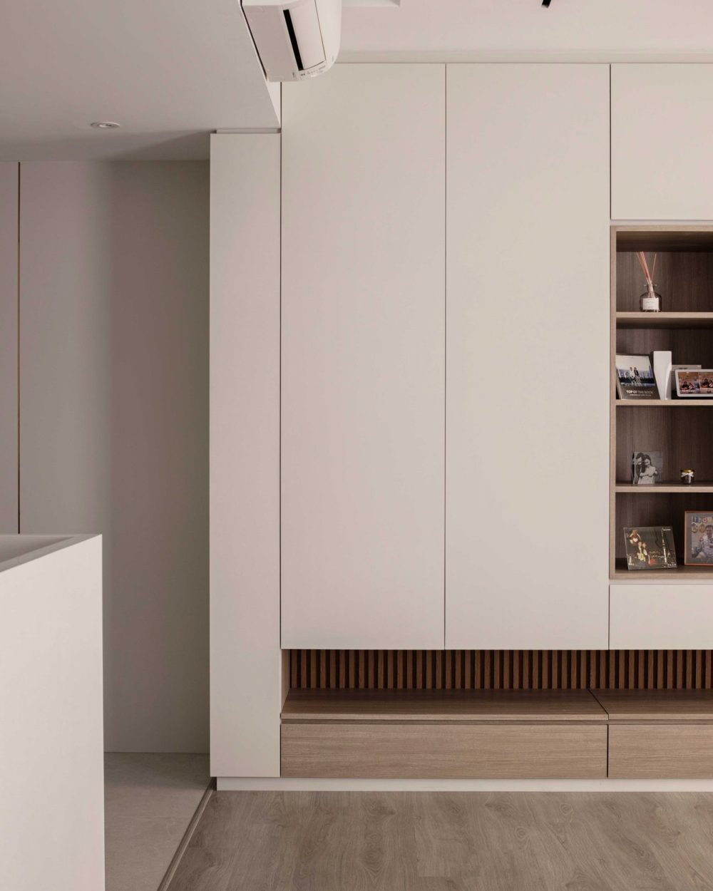 Framed family photographs and keepsakes are arranged on the living room's open shelving, adding warmth to the minimalist space.