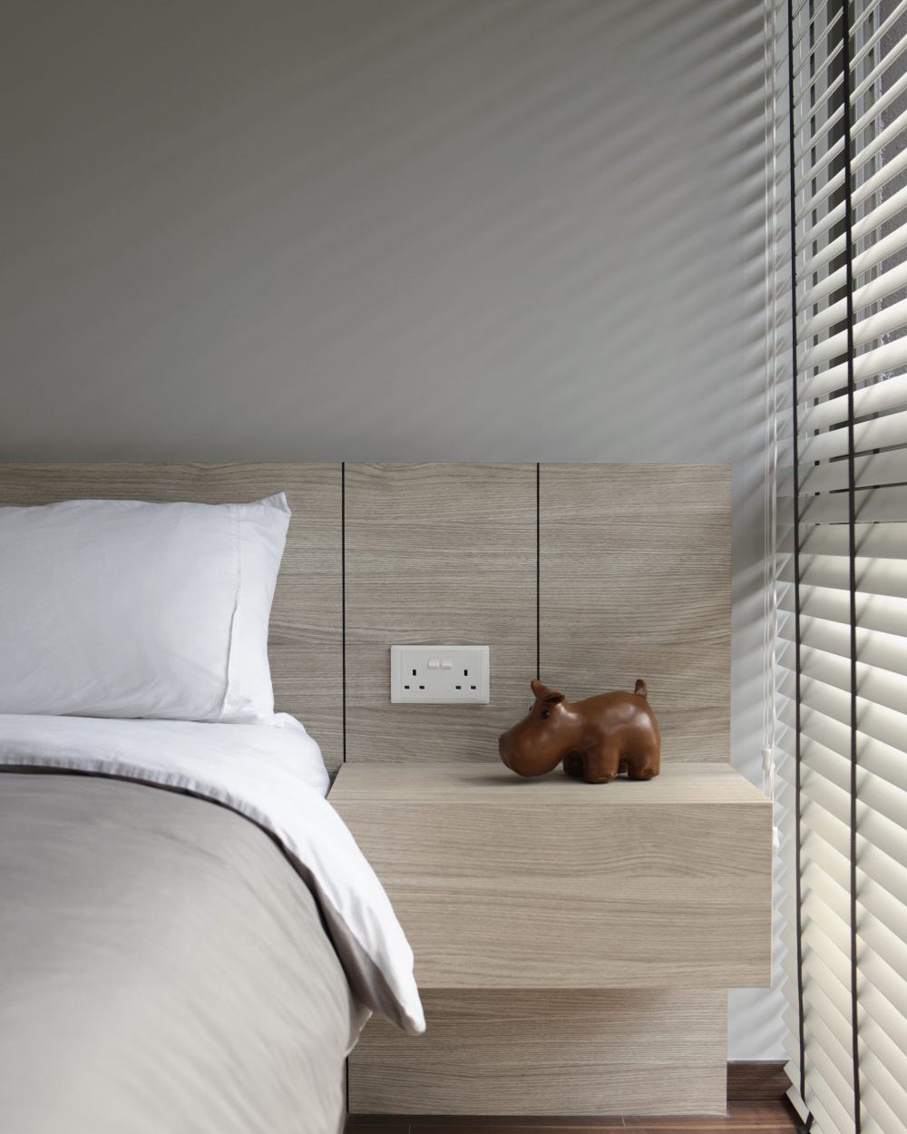 A small leather hippo figurine adds personality to the bedroom's built-in nightstand, softening the room's otherwise clean lines.