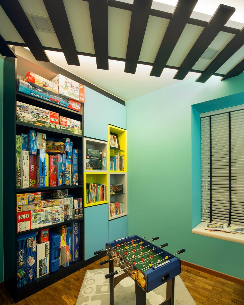 Bright cubby shelving in turquoise and yellow keeps toys and books organised, continuing the room's playful colour palette.
