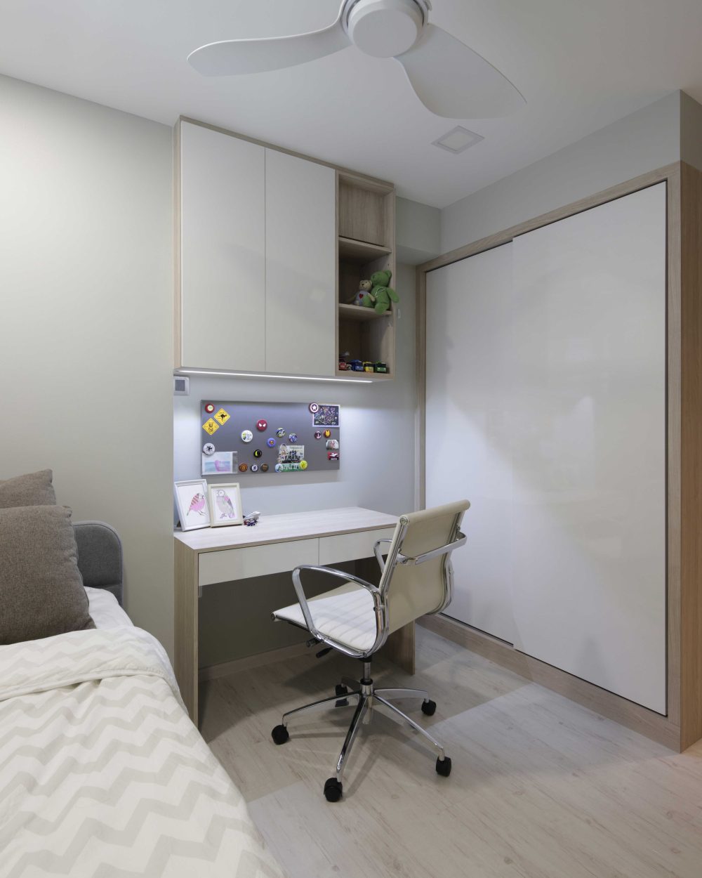 Open shelving, a magnetic pegboard and a sliding wardrobe door give the children's room a dedicated study and storage corner.