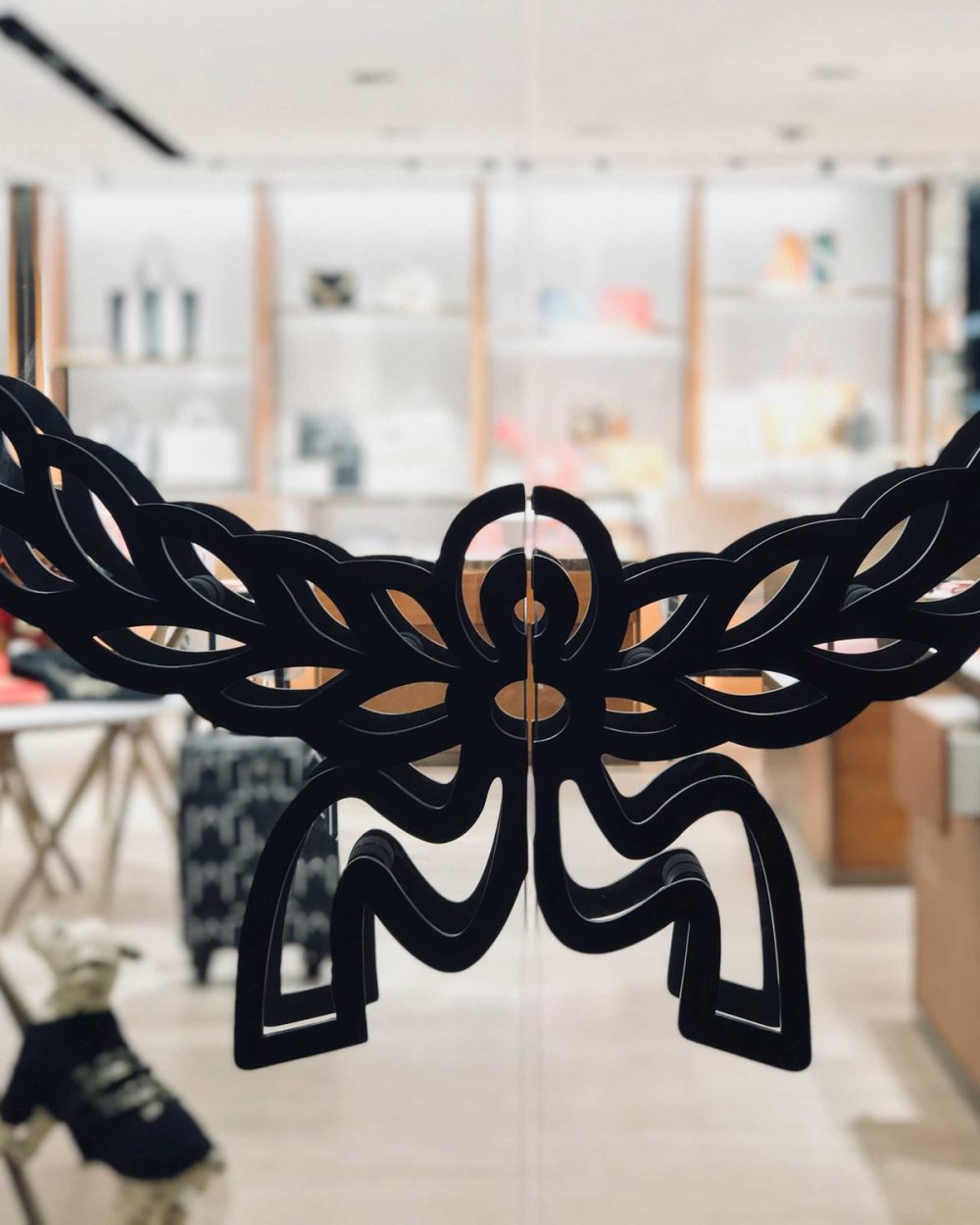 MCM's wing-and-flower brand emblem applied to the glass entrance doors at Paragon mall.