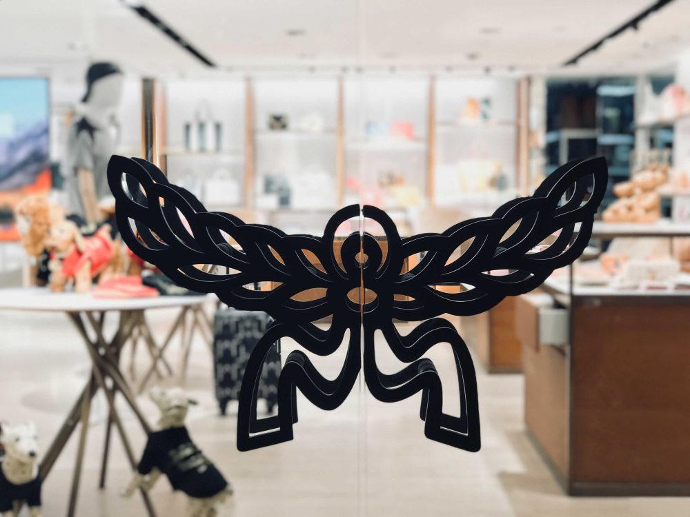 MCM's wing-and-flower brand emblem applied to the glass entrance doors at Paragon mall.