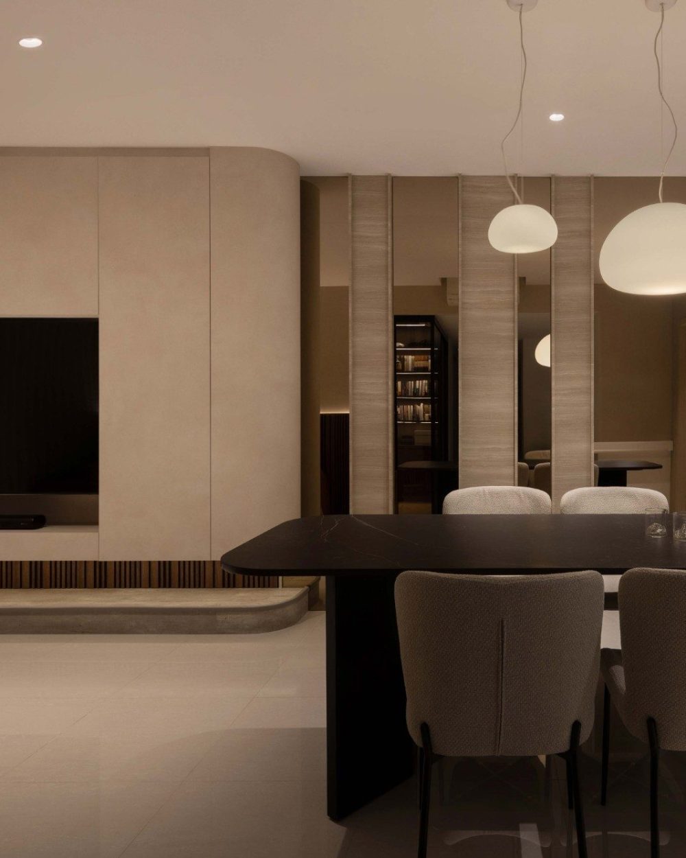 A pair of sculptural pendant lights hang low over the dining table, with the open-concept TV wall visible just beyond.