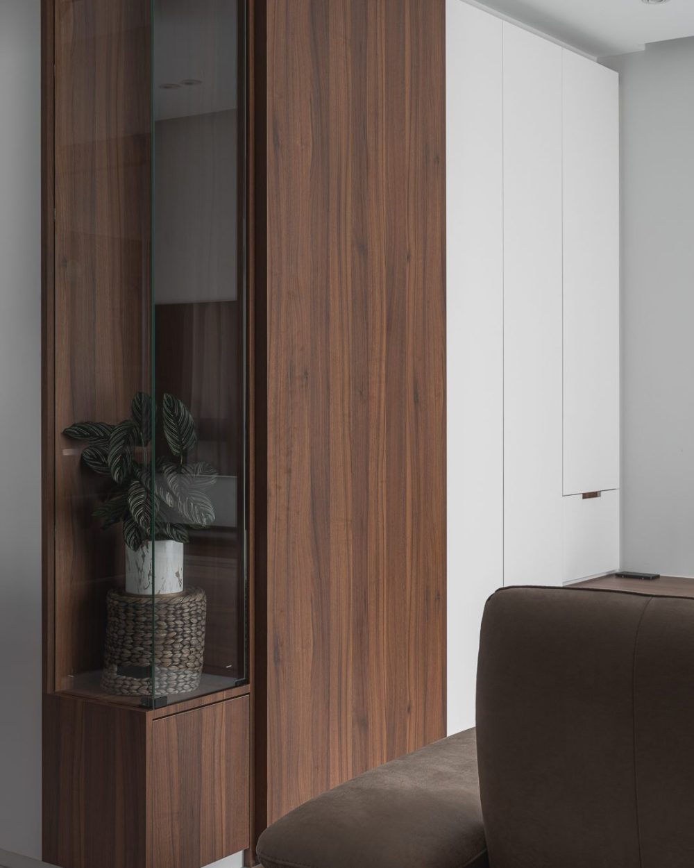 A closer look at where the walnut display cabinet meets the living room's white wardrobe wall.