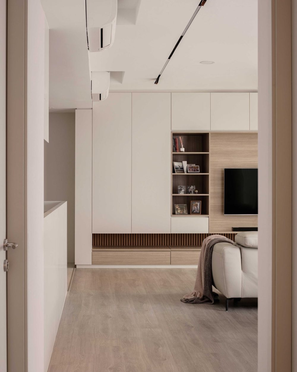 Integrated white cabinetry conceals a full-height refrigerator, keeping the kitchen's lines clean and uninterrupted.