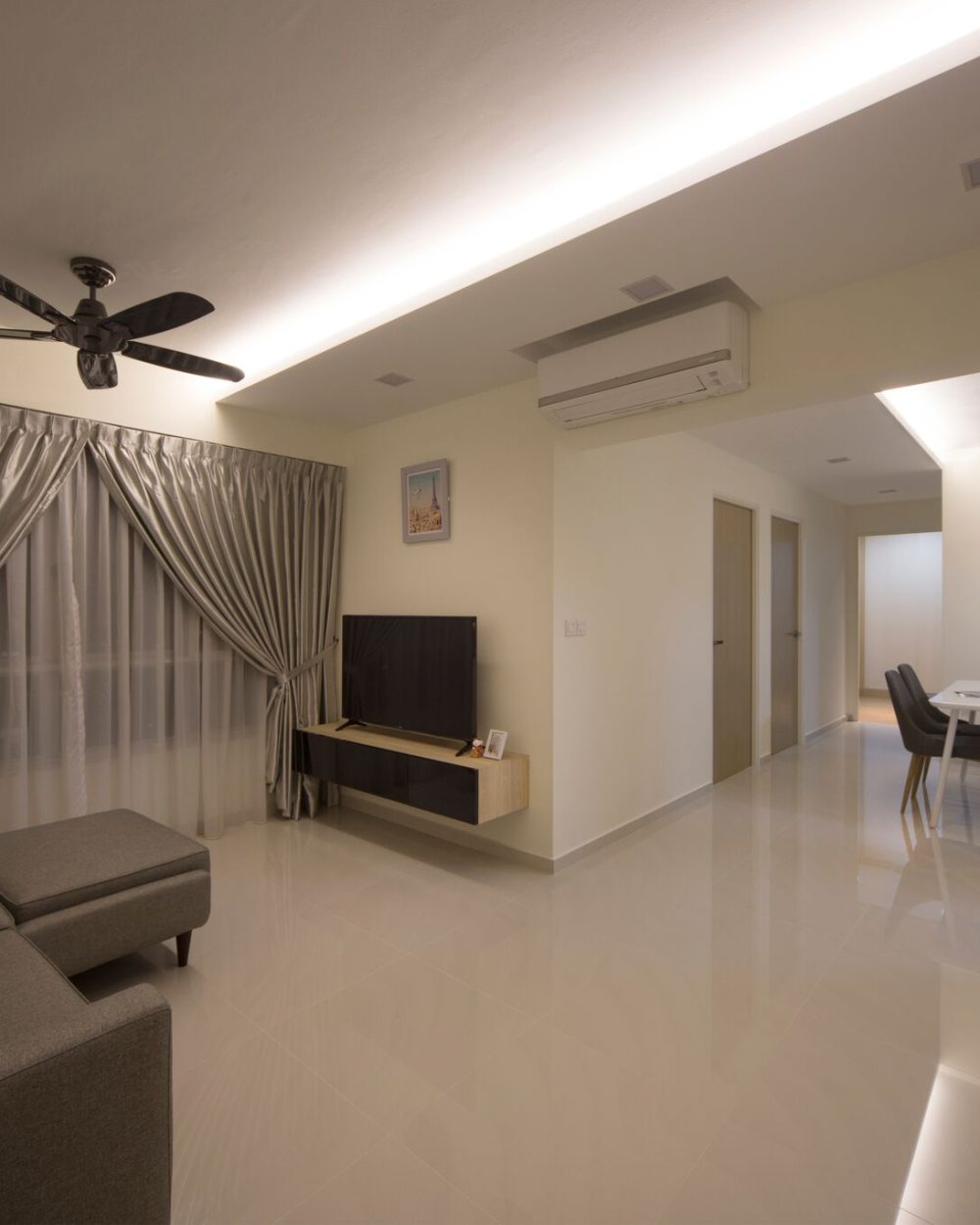 Shimmering silver curtains and a floating TV console define the living room, opening onto the dining area and kitchen beyond.