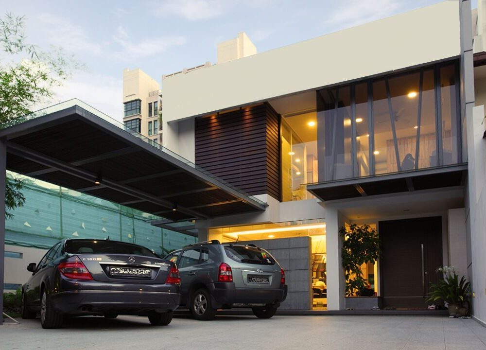 Vertical timber slats and full-height glazing give this landed home's facade a bold, architectural presence, lit up after dark.