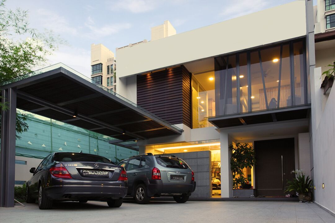 Vertical timber slats and full-height glazing give this landed home's facade a bold, architectural presence, lit up after dark.