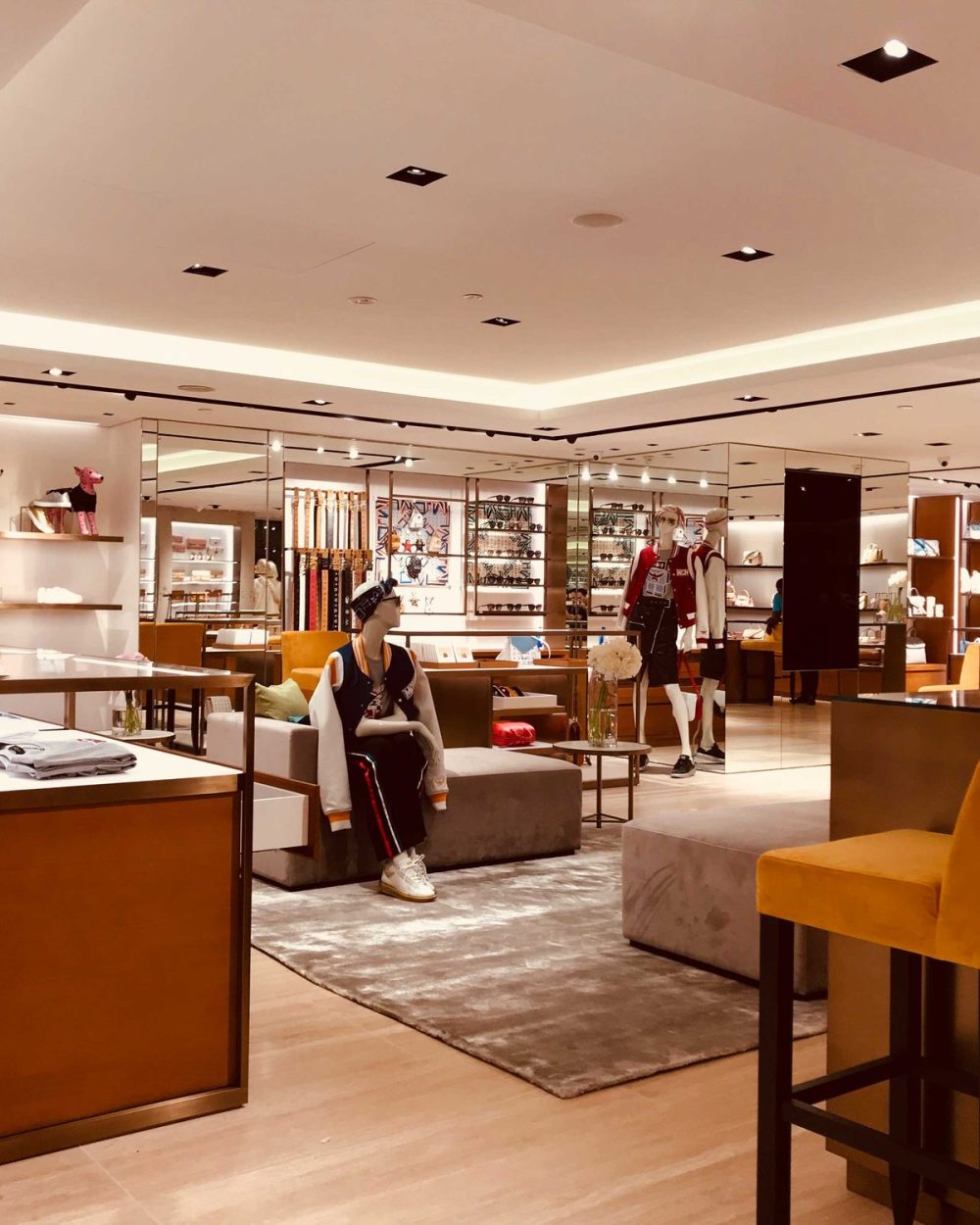A wide view of the MCM boutique with footwear, canine figures and lounge seating.
